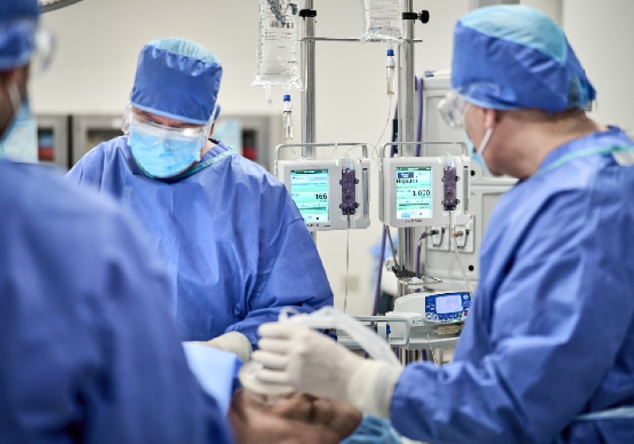 three hcps in surgery room performing healthcare